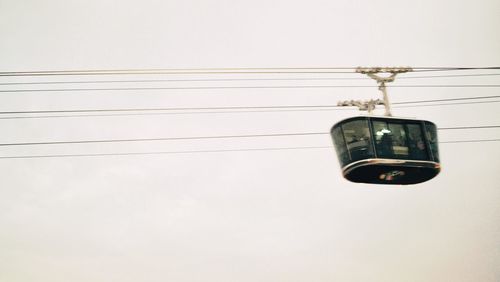 Low angle view of electric lamp against sky