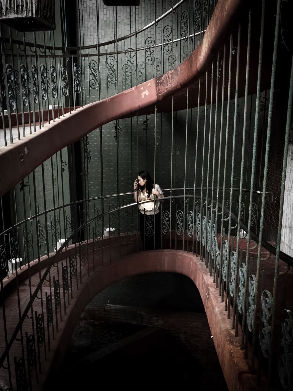 REAR VIEW OF A WOMAN IN CAGE AT RAILROAD STATION