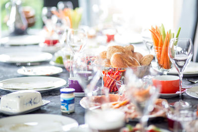 Buns in container with vegetables amidst plates on table