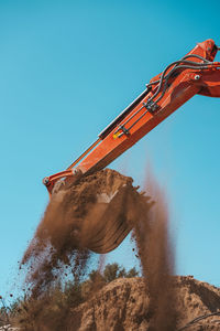 Low angle view of construction site against clear blue sky