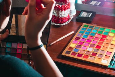 Woman in front of her dressing table holding her worn out eyeshadow palette