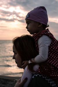 Midsection of woman wearing hat against sky during sunset