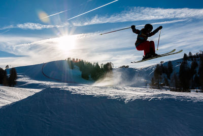 People skiing on snow against sky