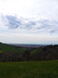 Scenic view of grassy field against cloudy sky