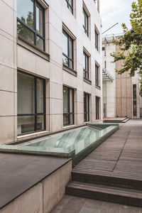 Empty footpath by building in city