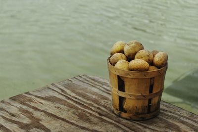 Close-up of bread on wood against lake