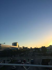 Cars on road in city against clear sky