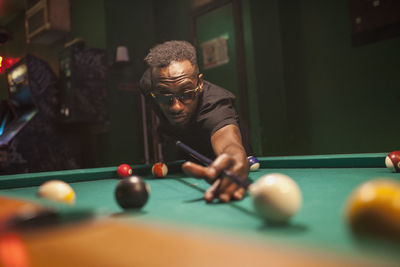 A young woman playing pool.