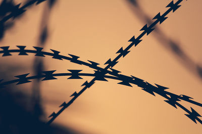 Low angle view of barbed wire against sky