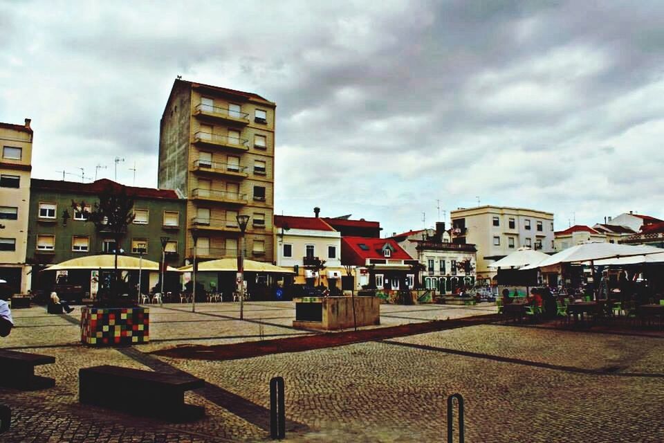 building exterior, architecture, built structure, sky, cloud - sky, cloudy, city, cloud, street, city life, men, person, walking, building, lifestyles, overcast, residential building, residential structure, incidental people