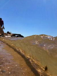 Scenic view of beach against clear blue sky