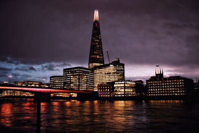 London skyline illuminated at night reflected in river thames 