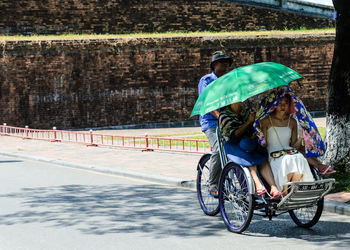 Rear view of man riding bicycle on street