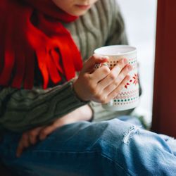 Midsection of boy holding mug while sitting at home