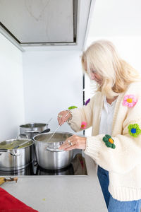 Rear view of young woman preparing food at home