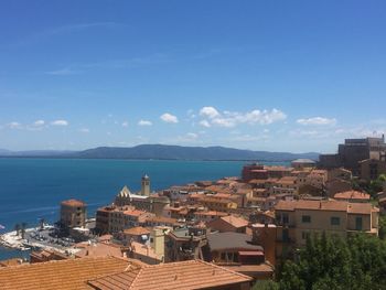 High angle view of townscape by sea against sky