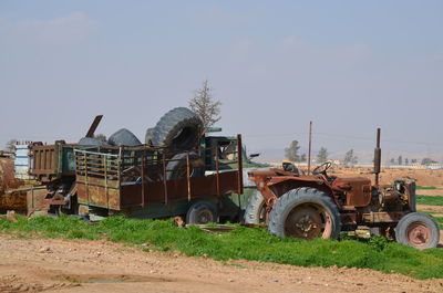 Tractor scrap on field against clear sky