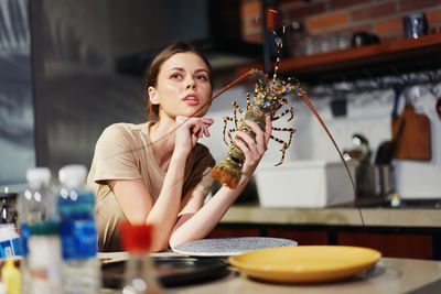 Portrait of smiling young woman having food at home