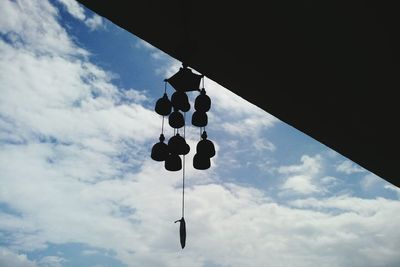 Low angle view of hanging light against sky