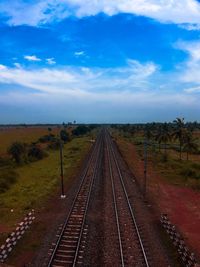Railroad tracks on field against sky