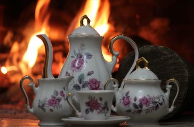 Close-up of crockery against fireplace