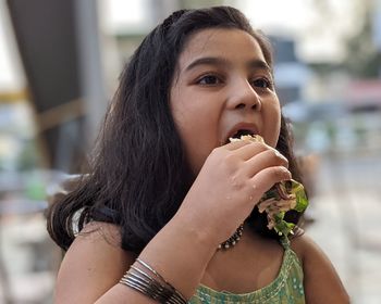 Portrait of  girl eating burger...