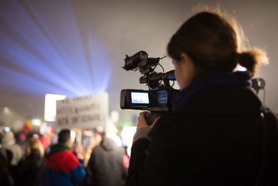 Woman photographing with mobile phone at music concert