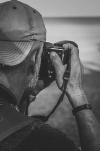 Close-up of man photographing with digital camera at beach