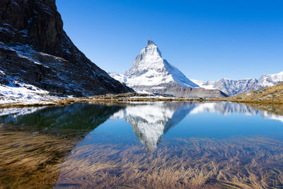 Scenic view of snowcapped matterhorn against sky during winter