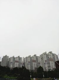 Buildings in city against clear sky