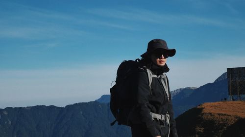 Man standing on mountain against sky