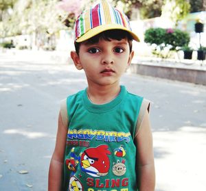 Portrait of cute boy wearing cap while standing on road