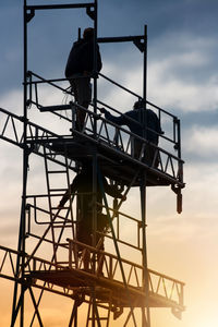 Low angle view of crane against sky