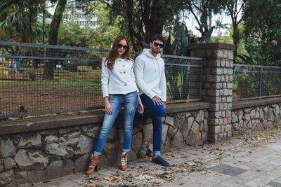 Full length portrait of young couple standing outdoors
