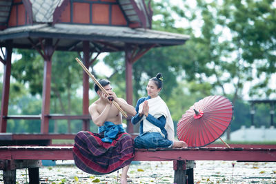 Full length of woman sitting outdoors