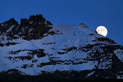 Low angle view of snowcapped mountain at gran paradiso national park at night