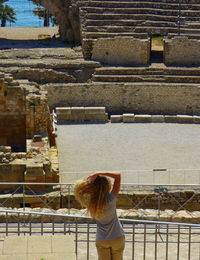 Rear view of woman sitting outside building