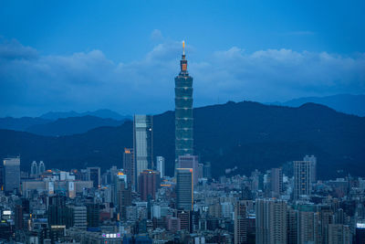 Buildings in city against cloudy sky