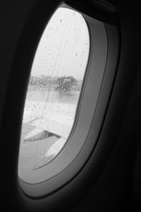 Close-up of wet airplane window in rainy season