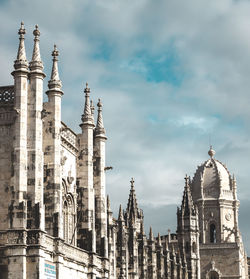 Low angle view of buildings against cloudy sky