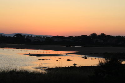 Scenic view of lake against romantic sky at sunset