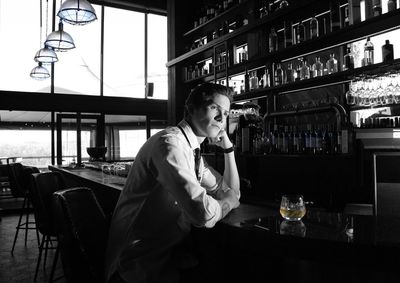 Man drinking glass on table at restaurant