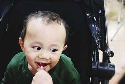 Close-up of baby boy eating lollipop in stroller