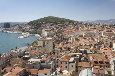 High angle view of townscape by sea against sky