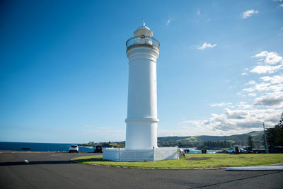 Lighthouse by sea against sky