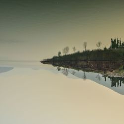 Scenic view of lake against sky at sunset