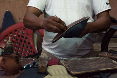 Midsection of man working on table