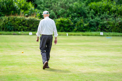 Rear view of man walking on golf course