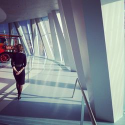 Woman standing on escalator