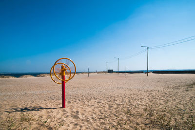 Lifeguard hut on beach against clear blue sky